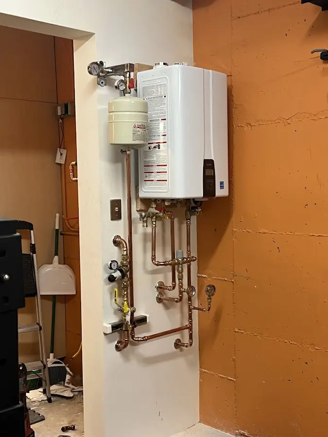 Plumbing technician inspecting water heater connections in Holly Springs